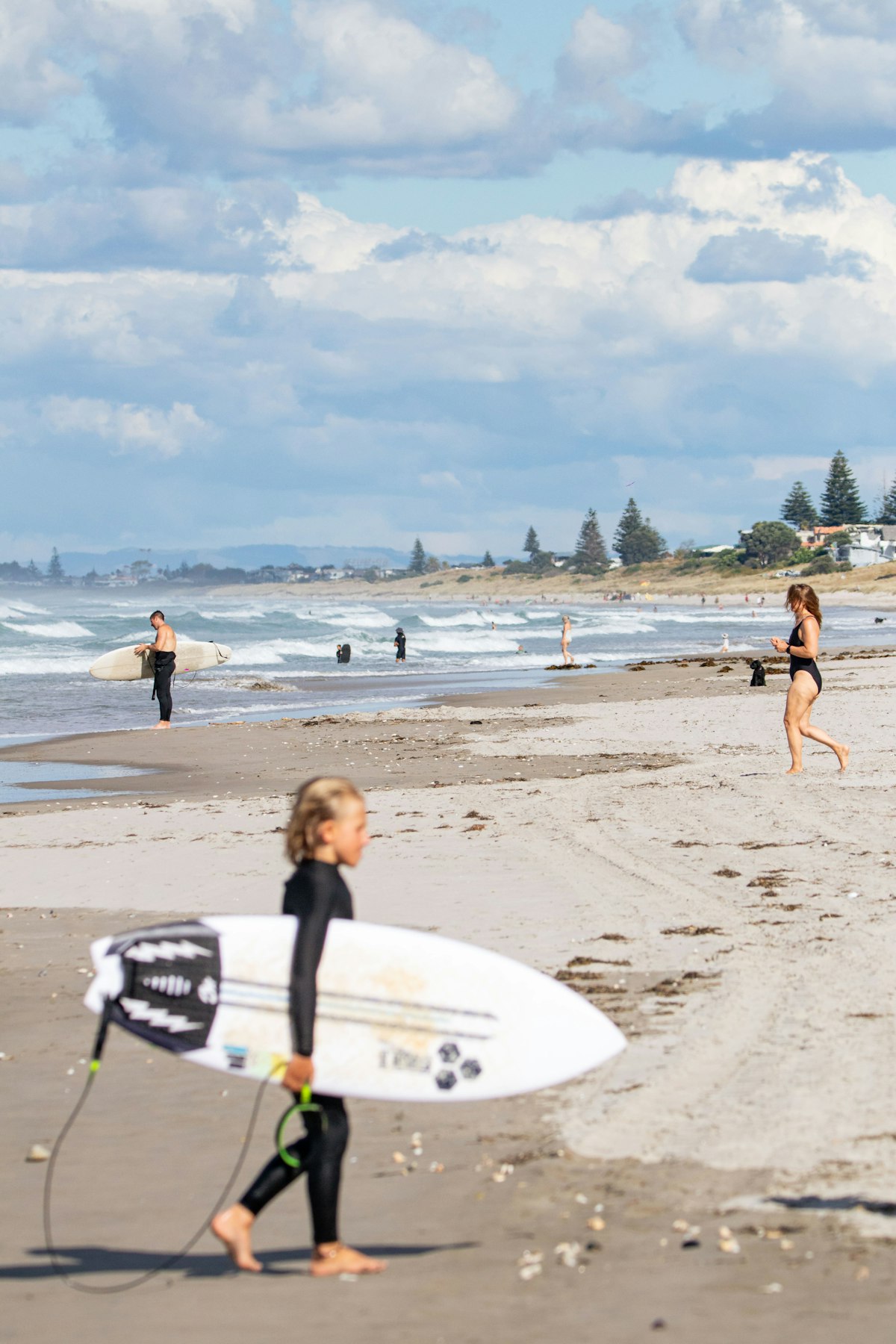 Surf clients walking with boards on the beach