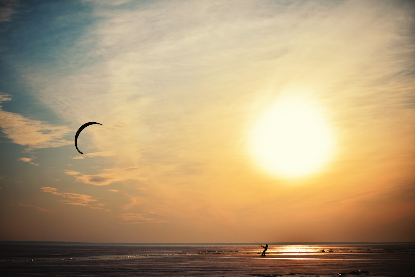 Kiteboarder riding at sunset on the coast
