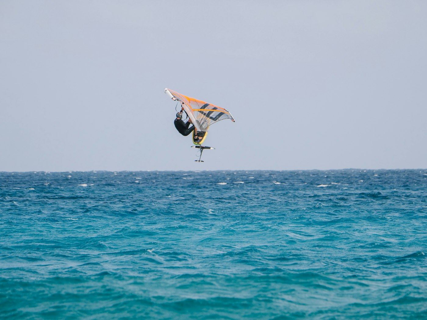 Wingfoiler gliding above blue water